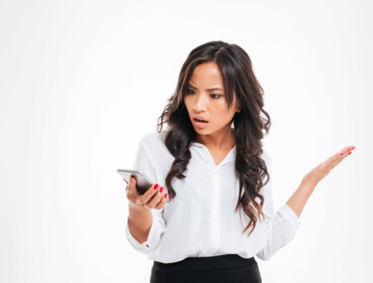 Disappointed,Confused,Asian,Businesswoman,Using,Smartphone,Isolated,On,A,White